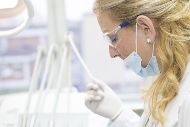 Endodontist using a dental microscope during root canal treatment